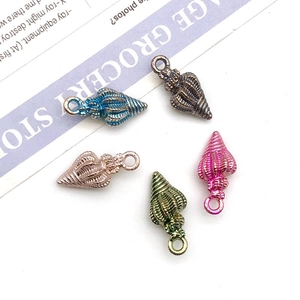 Detail view of colorful metal conch shell pendants for DIY jewelry and keychains