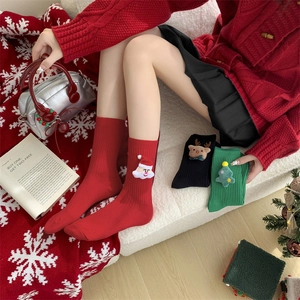 Close-up of festive Christmas socks with 3D cartoon embroidery on knit ribbed texture