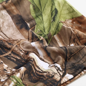 Close-up of tactical woodland camouflage fabric with realistic leaf and branch patterns