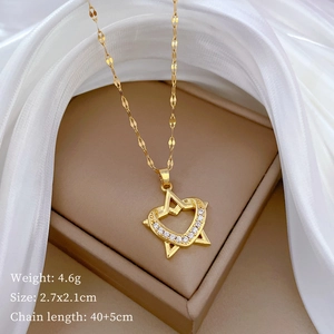 Close-up of gold star and heart pendant necklace with rhinestones on silk fabric
