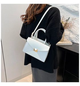 Détail du sac blanc en cuir texturé crocodile avec une boucle carrée en métal doré