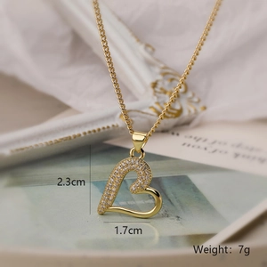 Macro view of gold heart pendant with zircon details and precise dimensions 23x17mm