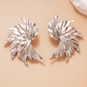 Close-up of silver-toned metal earrings with unique pleated leaf design and glossy finish