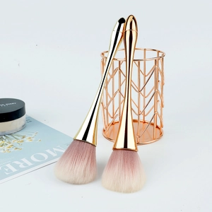 Detail of soft makeup brushes with rose gold handles and pink gradient bristles