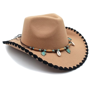 Detail of camel felt cowboy hat featuring bohemian beaded band and shell charms