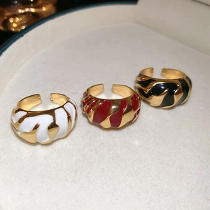 Macro shot of three irregular textured enamel drip rings in white, red and black