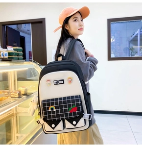 Detail of black and white plaid backpack with cute patches and plush bear charm