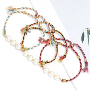 Detailed shot of three green braided rope bracelets with glass pearls on white background