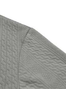 Macro detail of grey knitted jacquard fabric with geometric diamond texture on sweater