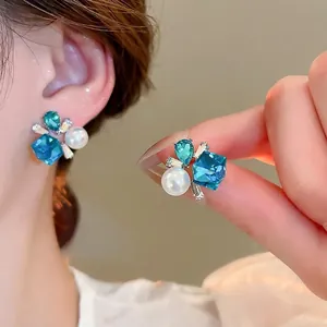 Elegant silver needle earrings with blue crystals, pearls, and diamonds for women