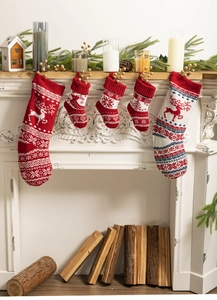 Classic knitted Christmas stockings with reindeer and snowflake patterns on a fireplace