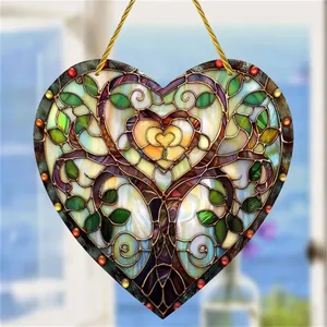 Detail of colorful acrylic tree of life heart suncatcher with sunlight reflecting through glass