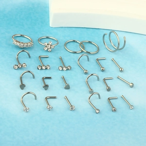 23-piece stainless steel nose ring set featuring silver hoops and crystal studs on blue