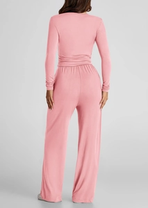 Vista posteriore di un completo rosa con maglia a maniche lunghe e pantaloni ampi
