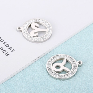 Detail of zodiac signs pendants with sparkling crystals on textured light blue background