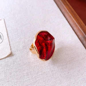 Detailed macro view of vintage gold ring with textured red enamel inlay and pleated gold finish