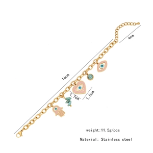 Détails d'un collier en acier doré avec pendentifs en forme de cœur, main et œil