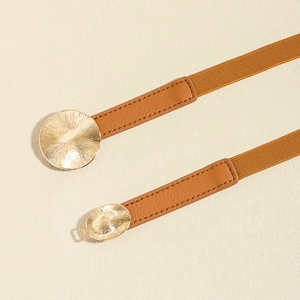 Detail of caramel elastic waist belt with gold metal buckles and textured faux leather
