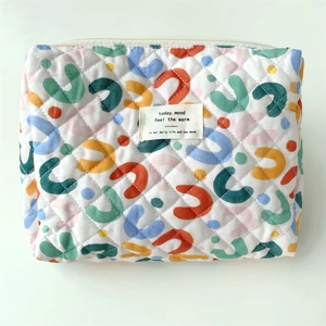 Top view of floral quilted cotton makeup bag with colorful abstract patterns and logo