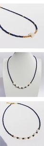 Detailed view of lapis lazuli beaded necklace with heart-shaped baroque pearl and gold accents
