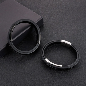 Close-up of men's triple-layer black braided leather bracelet with stainless steel bar