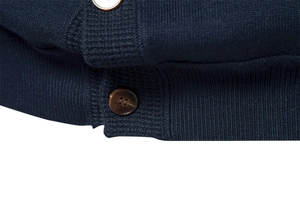 Detailed macro view of amber buttons and fine knit texture on a navy cardigan sweater