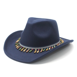 Close-up of ethnic geometric band and colorful wooden bead tassels on navy wool fedora hat