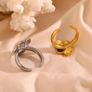 Detailed view of 18K gold and silver asymmetrical floral rings with inset diamonds