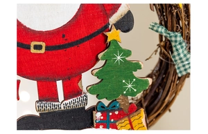 Detailed view of hand-painted wooden Santa Claus and gift box on a natural rattan wreath