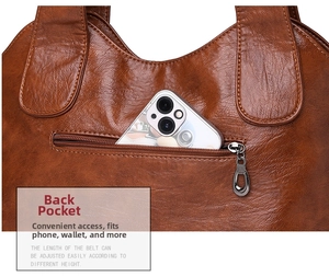 Detailed view of the back zipper pocket on a brown faux leather tote bag for phone storage