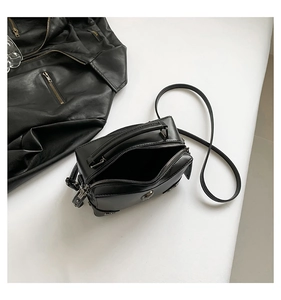 Top view of a black studded motorcycle bag with fine leather texture and top handle