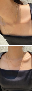 Detail of layered gold cross pendant necklaces on a model for a minimalist jewelry look