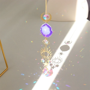 Golden suncatcher with purple agate slice and crystal prism creating rainbow light