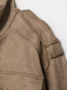 Macro shot of fine stitching and shoulder epaulet detail on a camel suede jacket