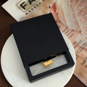 Black square PE film floating frame jewelry box displaying a gold necklace on marble