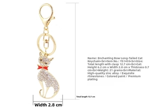 Close-up of golden cat keychain with white rhinestones and a red enamel bow detail
