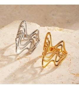 Detailed view of irregular 18K gold and silver rings on natural stone background