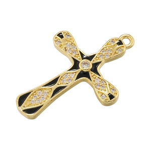Detailed close-up of golden cross pendant with black enamel inlay and clear cubic zirconia