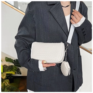 White woven texture crossbody bag with matching round coin purse charm worn by model