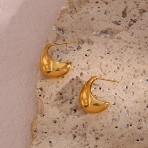 Boucles d'oreilles larmes dorées polies sur pierre naturelle avec ombres douces
