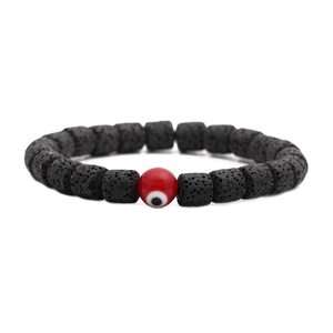 Detail von Lavastein-Perlenarmband mit einer auffälligen roten Evil-Eye-Glücksperle