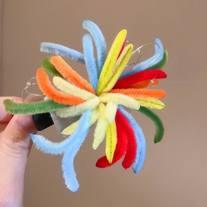 Detail showing the colorful fuzzy firework hair clip with integrated LED light filament