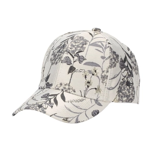Macro detail of ethnic floral jacquard fabric on a white baseball cap with golden threads