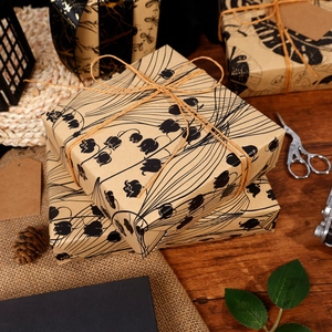Retro kraft gift wrapping paper with black lily of the valley prints and natural hemp rope