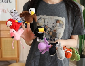 Detailed close-up of colorful plush sea animal finger puppets worn on a person's hand
