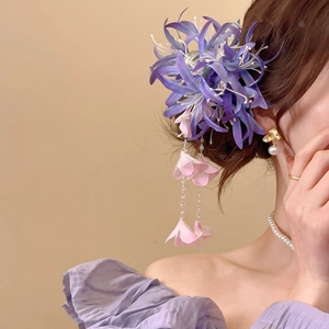 Détail de la pince à cheveux fleurie en tissu avec pompon de perles et pétales roses
