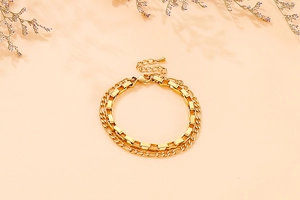 Close-up of double-layer gold chain bracelet with fine craftsmanship on a warm background