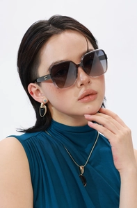 Detail of square polarized sunglasses with dark brown gradient lenses and jewelry set