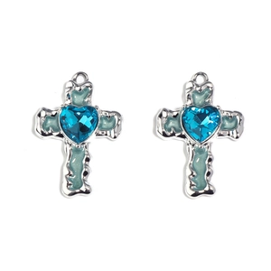 Close-up of silver cross pendant with blue heart crystal and light blue enamel detail