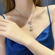 Detail of silver butterfly rose necklace with pearl pendant on a blue silk dress